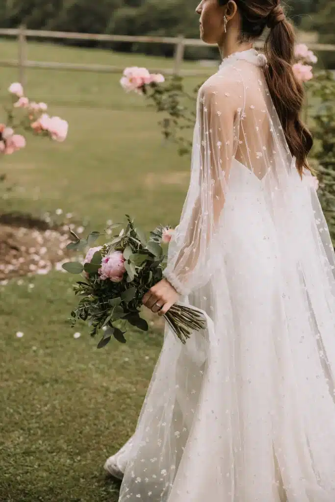Bride holding bouquet in open field at wedding in France