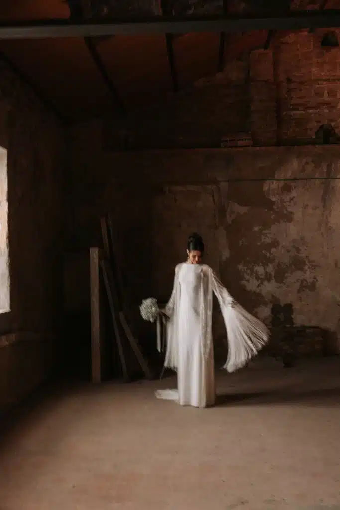 Bride standing in historic interior during wedding in Spain