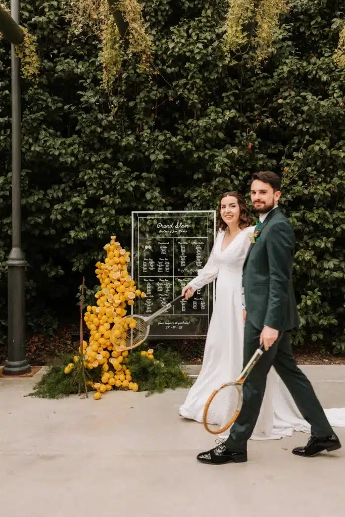 Bride and groom posing beside floral installation at wedding in England
