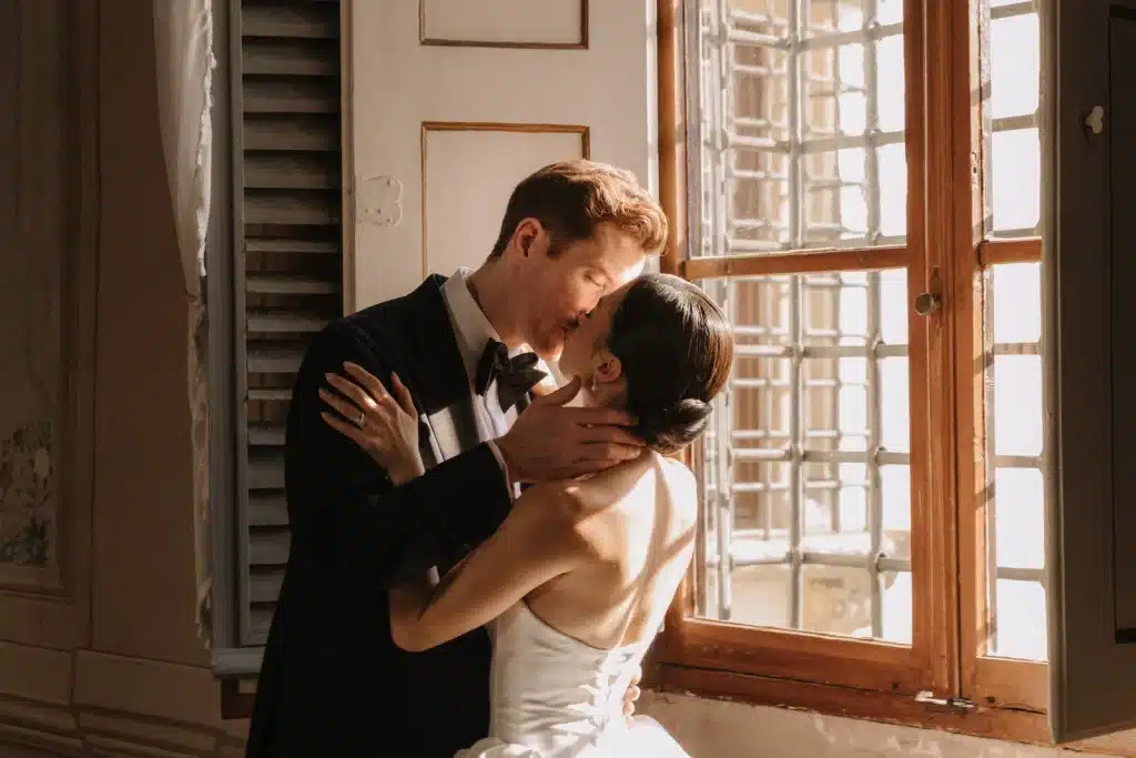 Romantic couple portrait by window at wedding in France