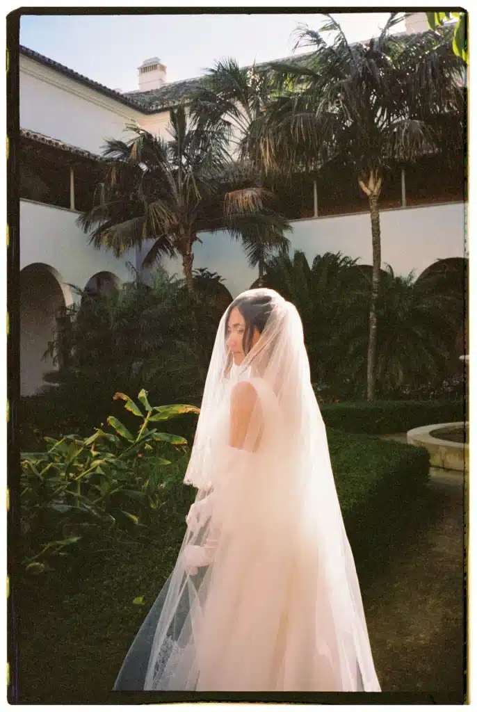 Bride framed by palm trees at destination wedding in Italy