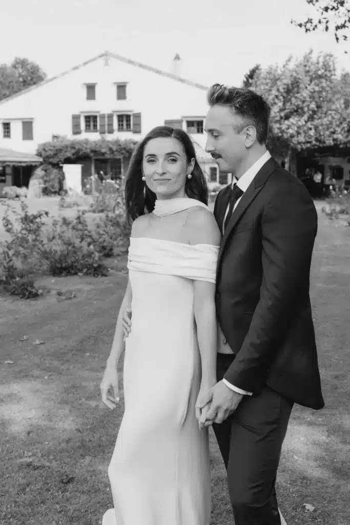 Newlyweds standing outside countryside estate during wedding in France