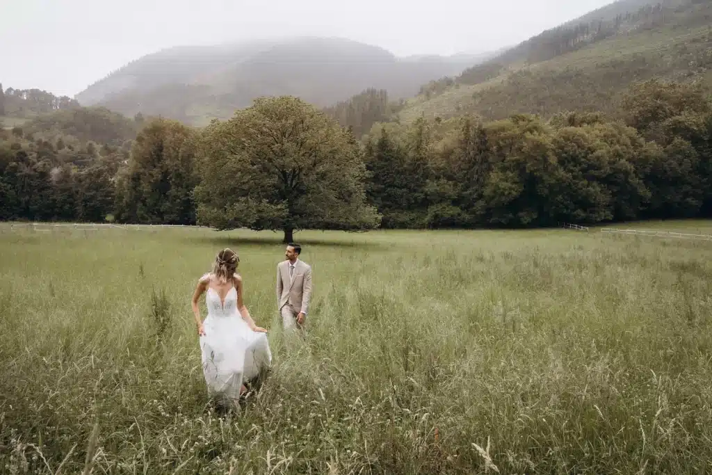 Bride and groom walking through fields after wedding ceremony in Spain