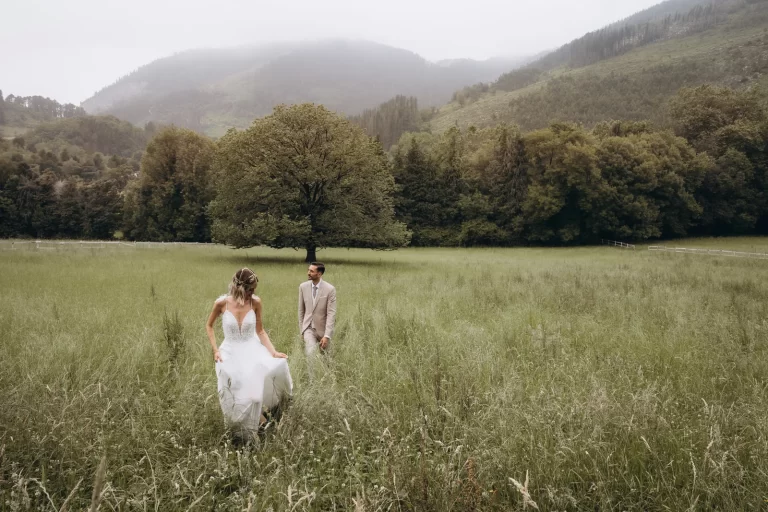 Bride and groom walking through fields after wedding ceremony in Spain