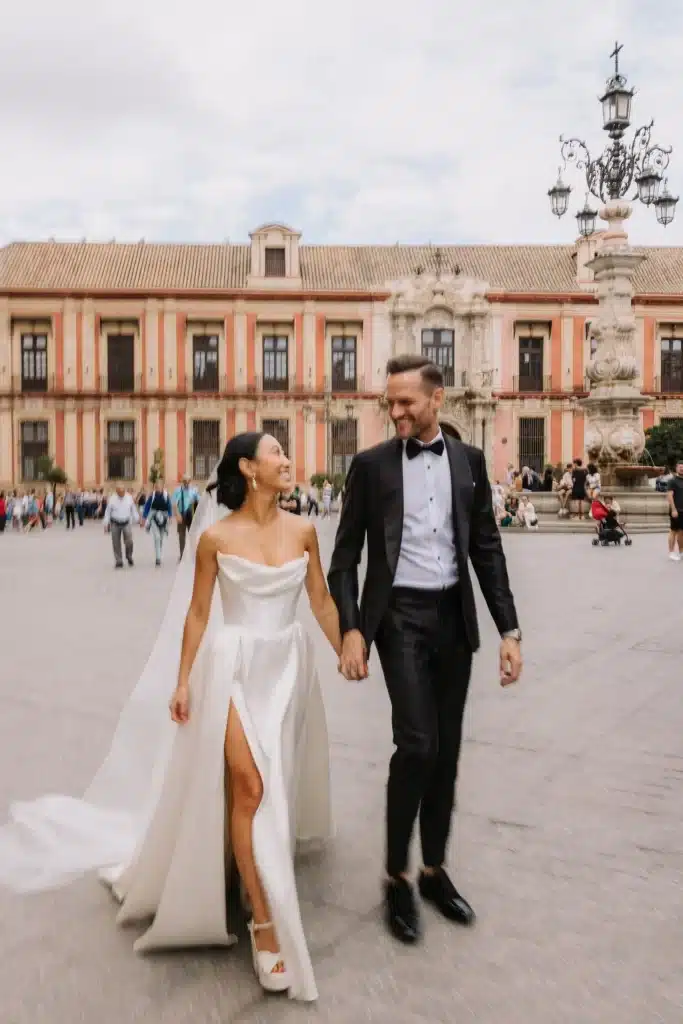 Bride and groom walking through historic Paris, France square