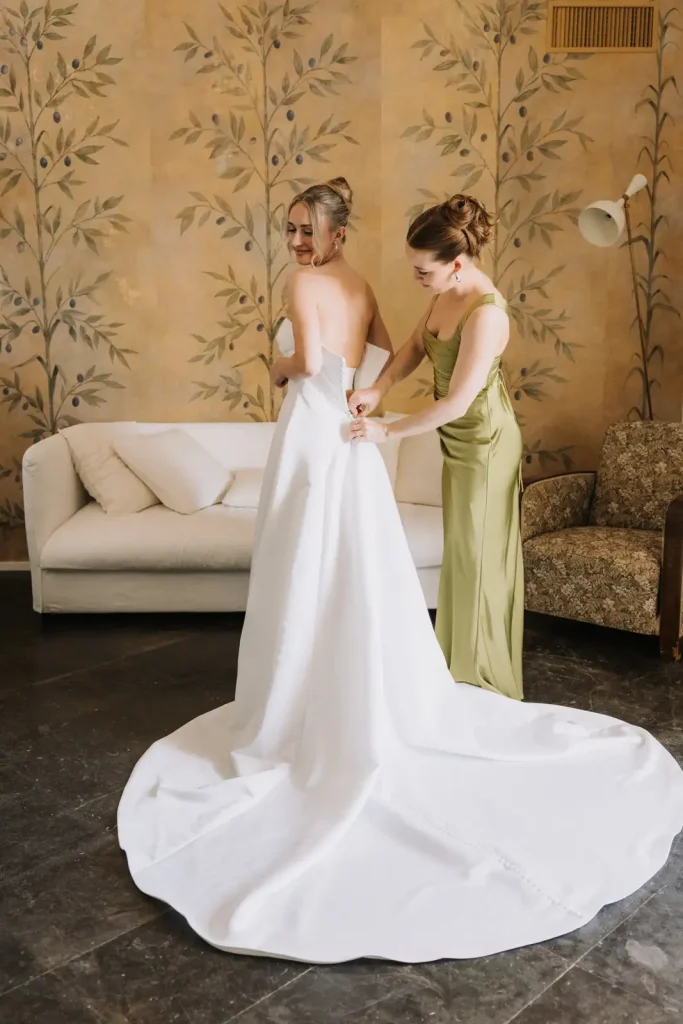 Bride wearing a Milla Nova wedding dress surrounded by bridesmaids while getting ready in Sicily