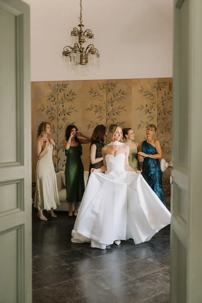 Bride wearing a Milla Nova wedding dress surrounded by bridesmaids while getting ready in Sicily